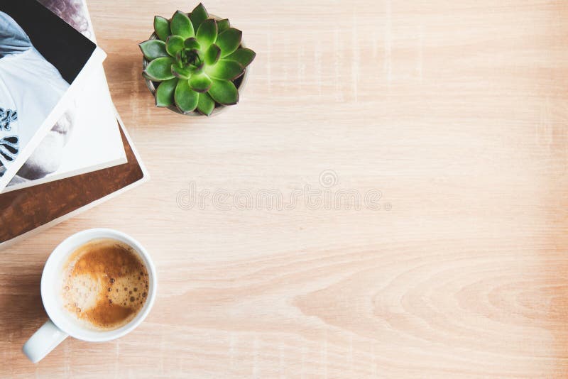 Top view of  books and magazines, cup of coffee and succulent plants over wooden background. Copy space. Concept of recreational time and space. Top view of  books and magazines, cup of coffee and succulent plants over wooden background. Copy space. Concept of recreational time and space.