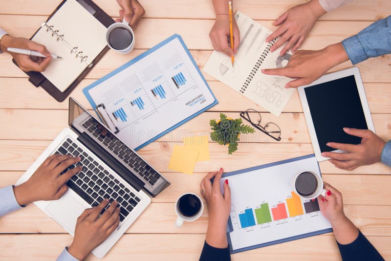 Vista superiore del posto di lavoro Soci commerciali che discutono progetto immagine stock libera da diritti Vista superiore del posto di lavoro Soci commerciali che discutono progetto immagine stock libera da diritti