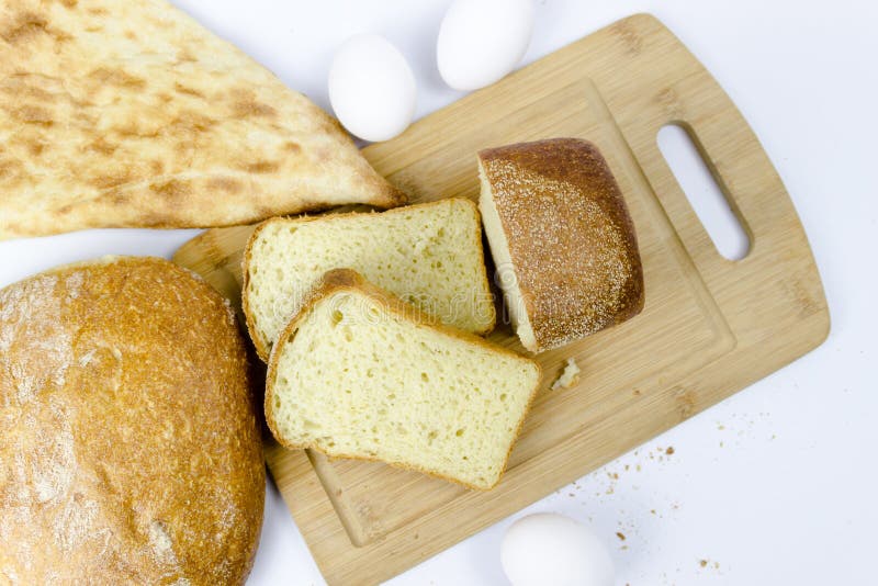 Vista superiore dell'assortimento del genere differente di forno del cereale: il pane, croissant, panini isolati su bianco woodde fotografie stock libere da diritti Vista superiore dell'assortimento del genere differente di forno del cereale: il pane, croissant, panini isolati su bianco woodde fotografie stock libere da diritti