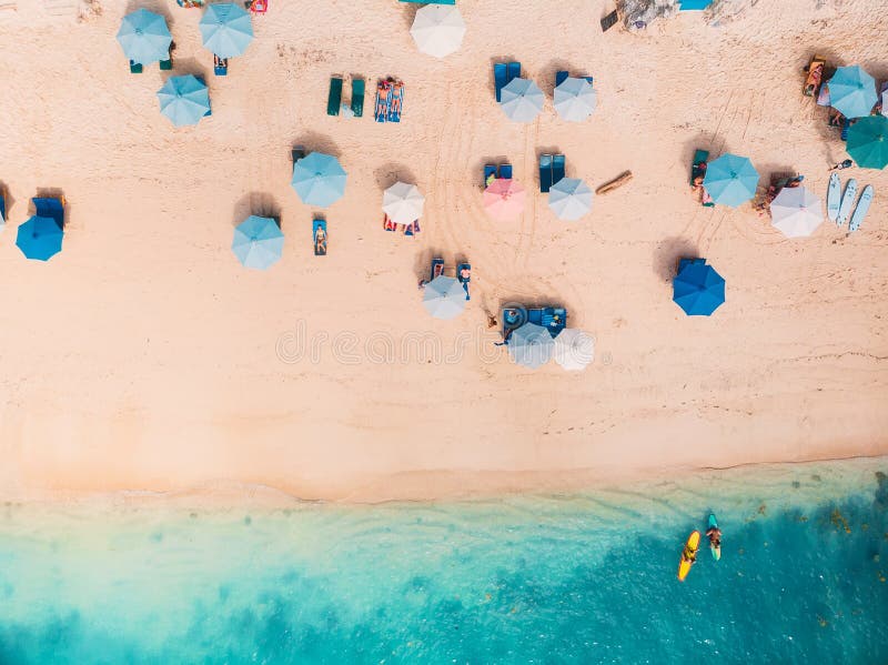 Vista superiore della spiaggia sabbiosa con l'acqua di mare del turchese e gli ombrelli blu variopinti, colpo aereo del fuco immagini stock