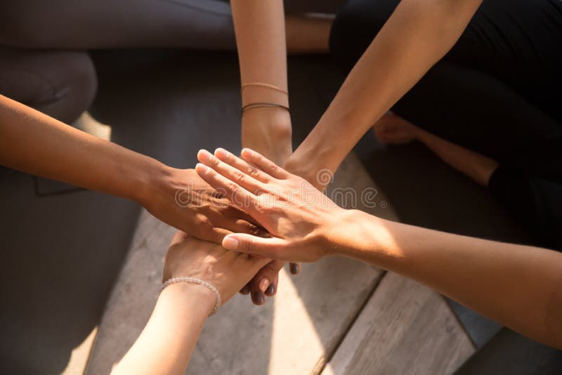 Vista superiore delle mani della pila delle donne impegnate nell'attività di team-building fotografia stock libera da diritti Vista superiore delle mani della pila delle donne impegnate nell'attività di team-building fotografia stock libera da diritti