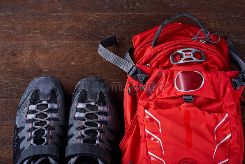 Vista superiore dello zaino turistico e delle scarpe allegre sui bordi di legno immagine stock Vista superiore dello zaino turistico e delle scarpe allegre sui bordi di legno immagine stock