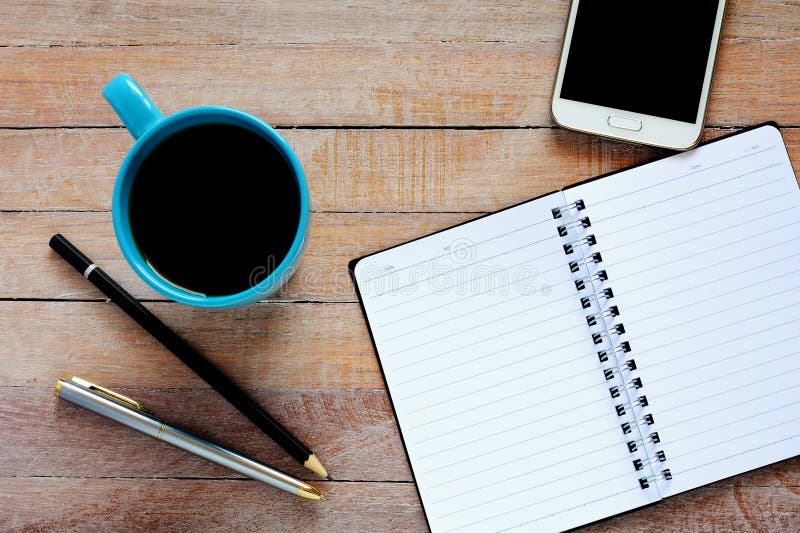 Vista superiore sul taccuino, sullo smartphone, sulla penna e sulla tazza di caffè aperti immagini stock libere da diritti