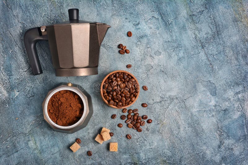 Vista superiore sulla macchinetta del caffè aperta del geyser con caffè macinato ed i fagioli per il caffè espresso di mattina immagine stock Vista superiore sulla macchinetta del caffè aperta del geyser con caffè macinato ed i fagioli per il caffè espresso di mattina immagine stock