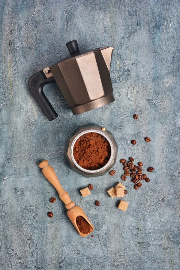 Vista superiore sulla macchinetta del caffè aperta del geyser con caffè macinato ed i fagioli per il caffè espresso di mattina immagini stock Vista superiore sulla macchinetta del caffè aperta del geyser con caffè macinato ed i fagioli per il caffè espresso di mattina immagini stock