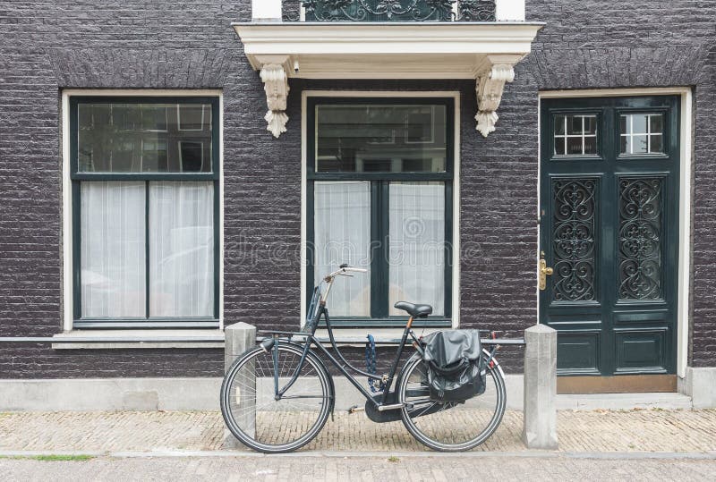 Vista tipica della via di Amsterdam nei Paesi Bassi con le vecchie porte e finestre e bicicletta d'annata fotografia stock libera da diritti Vista tipica della via di Amsterdam nei Paesi Bassi con le vecchie porte e finestre e bicicletta d'annata fotografia stock libera da diritti