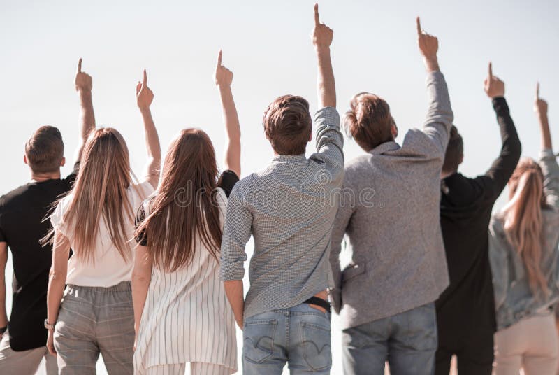 Vista traseira um grupo de juventude do negócio que aponta acima em um espaço da cópia imagem de stock royalty free Vista traseira um grupo de juventude do negócio que aponta acima em um espaço da cópia imagem de stock royalty free