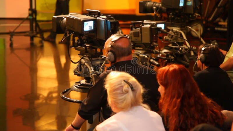 Vista trasera de camarógrafos y espectadores en gran televisión metrajes