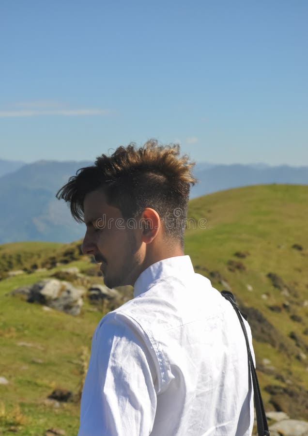 Vista trasera de un joven de buen aspecto parado en la naturaleza con los ojos cerrados fotos de archivo libres de regalías