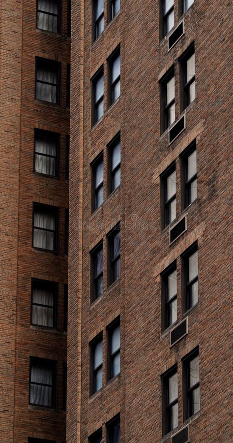 Vista vertical de un edificio de ladrillo marrón con numerosas ventanas foto de archivo