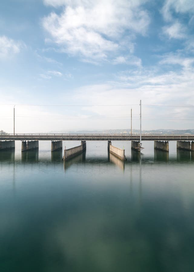 Vista verticale di un ponte concreto sopra acqua con una linea del treno e un parallelo di funzionamento della strada e un passag fotografia stock libera da diritti Vista verticale di un ponte concreto sopra acqua con una linea del treno e un parallelo di funzionamento della strada e un passag fotografia stock libera da diritti