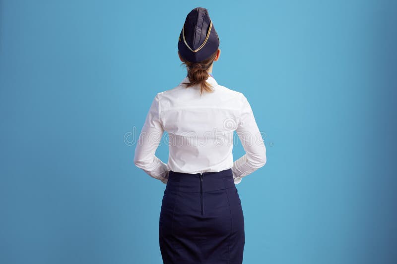 Visto desde detrás de elegante azafata de aire mujer en azul