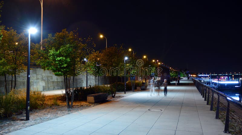 Vistulan Boulevards aan de westelijke kant van de rivier de Vistula in Warschau in de nacht De promenade aan de oever van de rivi stock foto Vistulan Boulevards aan de westelijke kant van de rivier de Vistula in Warschau in de nacht De promenade aan de oever van de rivi stock foto