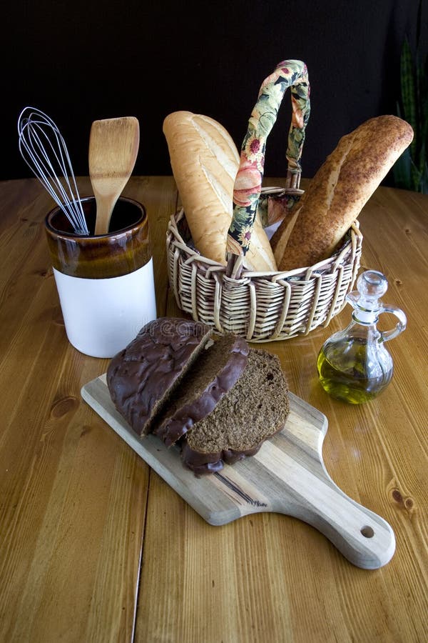 Various breads displayed on a table with a jar and a cruet of olive oil. Various breads displayed on a table with a jar and a cruet of olive oil.