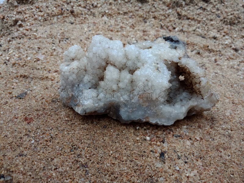 Vit crystal sten på sanden med textur texturerad bakgrundstapet, strand hav arkivfoton Vit crystal sten på sanden med textur texturerad bakgrundstapet, strand hav arkivfoton