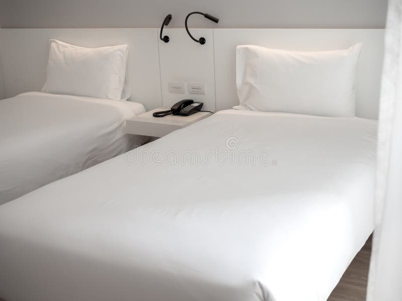 Vit ren tvilling- säng med vita kuddar i hotellsovrum arkivbilder Vit ren tvilling- säng med vita kuddar i hotellsovrum arkivbilder