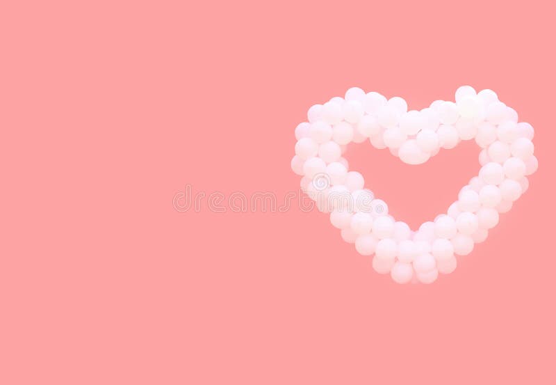 Vit sväller i form av hjärta på en rosa bakgrund royaltyfri bild Vit sväller i form av hjärta på en rosa bakgrund royaltyfri bild