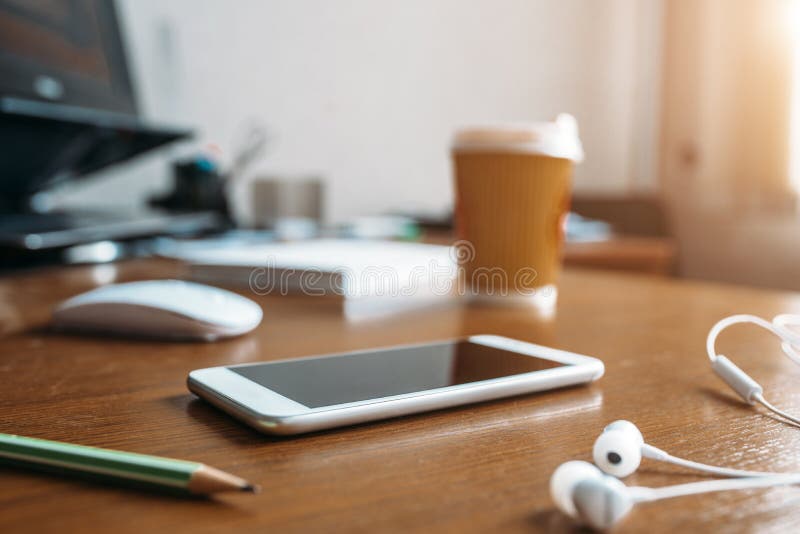 Vit telefon, hörlurar, mus och kopp kaffe arkivfoton Vit telefon, hörlurar, mus och kopp kaffe arkivfoton