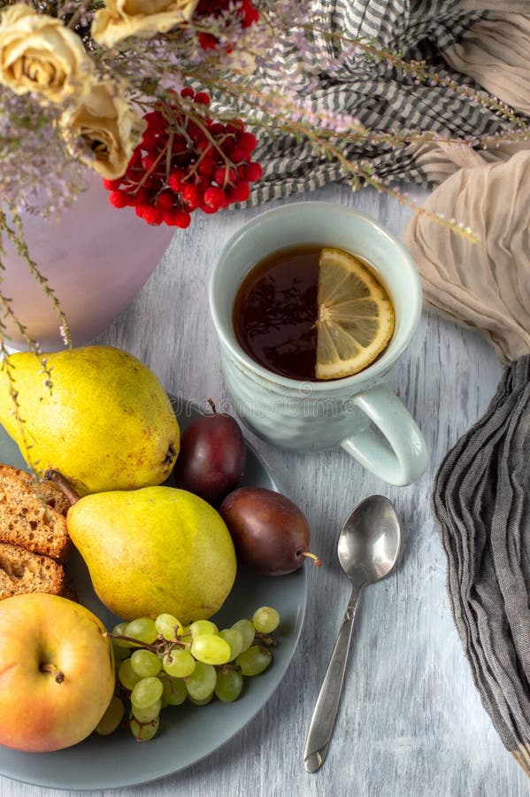 Vita ancora con una tazza di tè un vaso con una bouquet di frutta e un muffin alla banana immagine stock