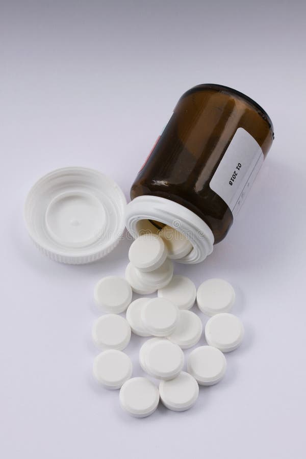 Vita preventivpillerar som spills från den stupade preventivpillerflaskan Preventivpillerar och medicinbehållare som ligger på vi arkivbilder Vita preventivpillerar som spills från den stupade preventivpillerflaskan Preventivpillerar och medicinbehållare som ligger på vi arkivbilder