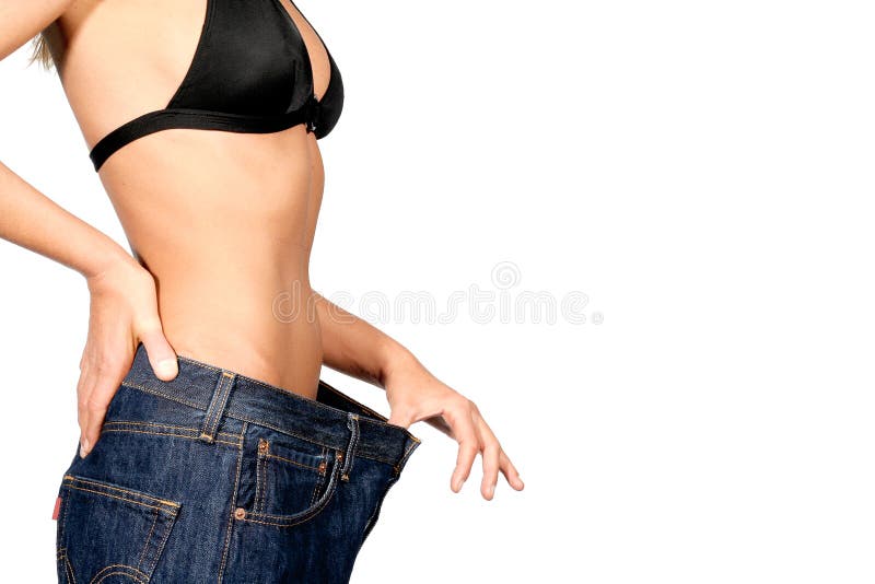 A model who has lost weight showing the loosening of her jeans at the waist, on a white background. A model who has lost weight showing the loosening of her jeans at the waist, on a white background