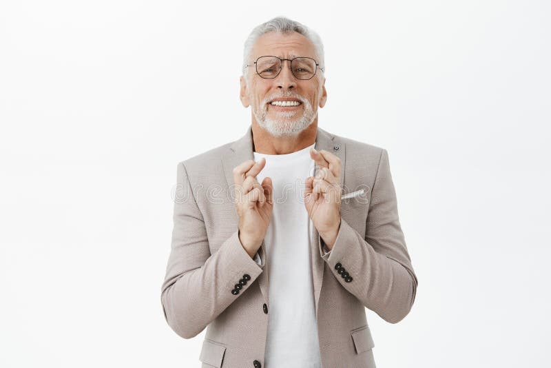Vita-su sparata dell'uomo maturo promettente intenso in vetri d'uso di bisogno e dita d'attraversamento del vestito elegante per immagini stock Vita-su sparata dell'uomo maturo promettente intenso in vetri d'uso di bisogno e dita d'attraversamento del vestito elegante per immagini stock