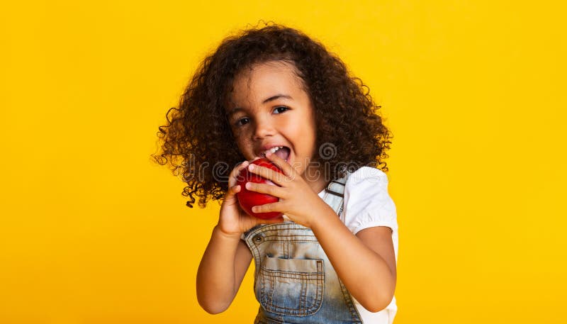 Vitamin snack. Little girl biting red apple