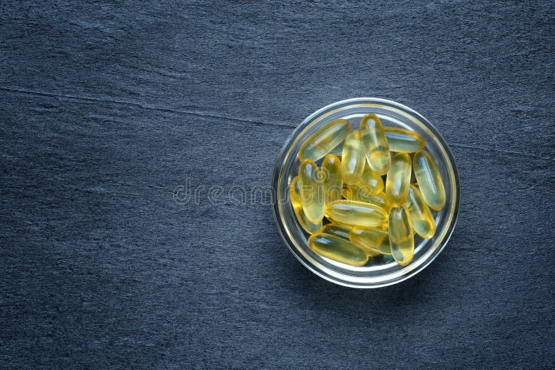 Vitamine D gel capsules on dark background