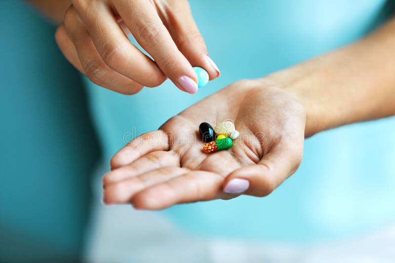 Vitamine e supplementi Mano femminile che tiene le pillole variopinte