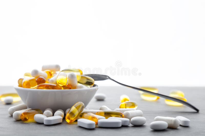 vitaminen, pillen, geneesmiddelen in kom met metaallepel op grijze achtergrond Witte voedingssupplementen, hard gedopt royalty-vrije stock fotografie vitaminen, pillen, geneesmiddelen in kom met metaallepel op grijze achtergrond Witte voedingssupplementen, hard gedopt royalty-vrije stock fotografie