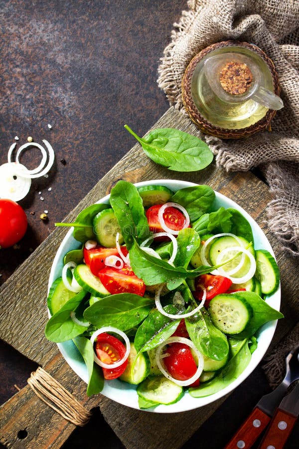 Vitaminsnack. Sallad med färska grönsaker och spenat royaltyfri bild