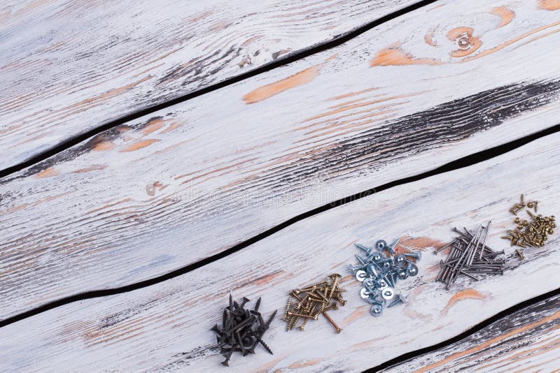 Viti nere, d'argento e dorate su fondo di legno fotografia stock libera da diritti Viti nere, d'argento e dorate su fondo di legno fotografia stock libera da diritti