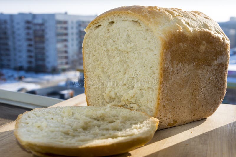 Vitt hemlagat bröd med ett stycke på fönstret arkivfoton Vitt hemlagat bröd med ett stycke på fönstret arkivfoton