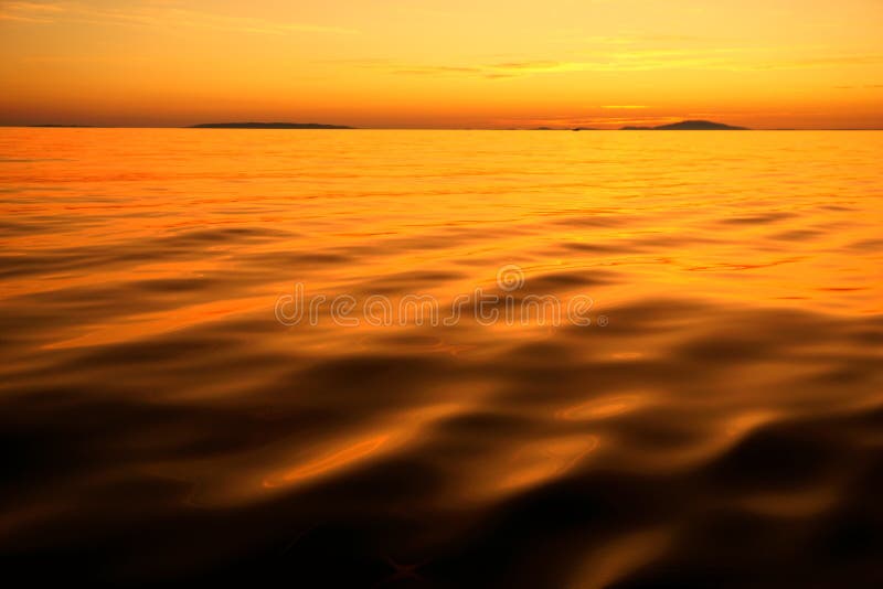 Vivid orange color sunset with unreal colorful water surface and sky. Abstract nature background with color like on an unknown