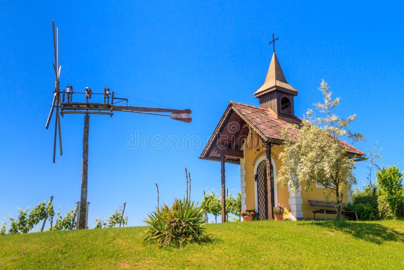 Viñedo de Styrian Toscana con la pequeños capilla y molino de viento, Estiria, foto de archivo Viñedo de Styrian Toscana con la pequeños capilla y molino de viento, Estiria, foto de archivo