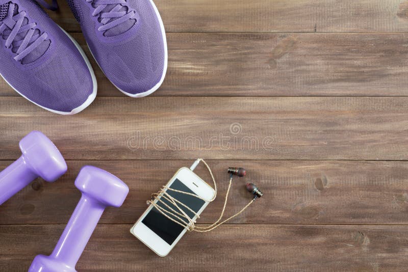 Vlak leg de hoogste toebehoren van de meningsgeschiktheid op een houten achtergrond Smartphone, purpere domoren, purpere loopscho stock fotografie Vlak leg de hoogste toebehoren van de meningsgeschiktheid op een houten achtergrond Smartphone, purpere domoren, purpere loopscho stock fotografie