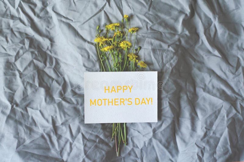 Vlak leg met bloemen en een prentbriefkaar van gelukwensen op de dag van een gelukkige moeder stock fotografie Vlak leg met bloemen en een prentbriefkaar van gelukwensen op de dag van een gelukkige moeder stock fotografie