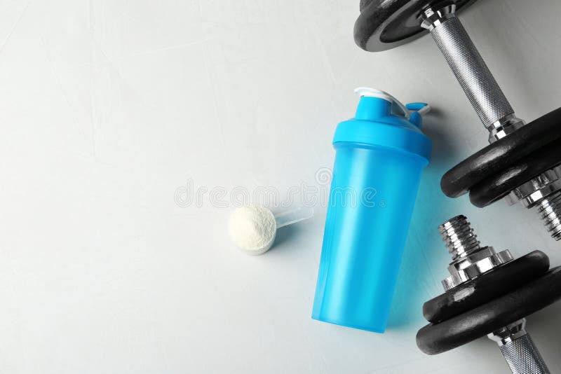 Vlak leg samenstelling met de lege eiwitfles en het poeder van de schoksport op lijst royalty-vrije stock foto Vlak leg samenstelling met de lege eiwitfles en het poeder van de schoksport op lijst royalty-vrije stock foto