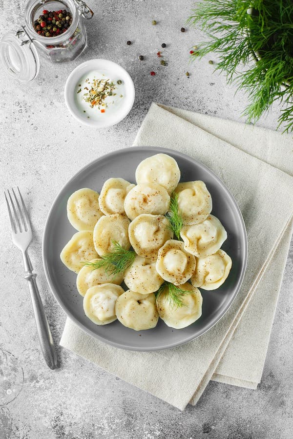 Meat dumplings - russian pelmeni, ravioli with meat on a grey plate. Flat lay composition. Food photography. Meat dumplings - russian pelmeni, ravioli with meat on a grey plate. Flat lay composition. Food photography