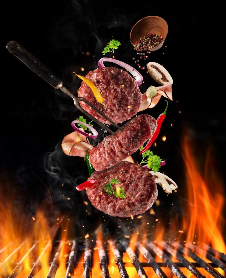Vliegend ruw gemalen rundvleesvlees met ingrediënten boven grillbrand