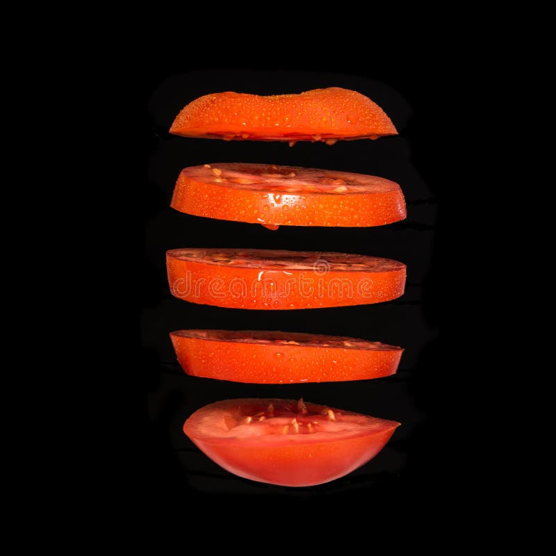 Vliegende tomaat Gesneden rode die tomaat op zwarte achtergrond wordt geïsoleerd Levity het plantaardige drijven in de lucht