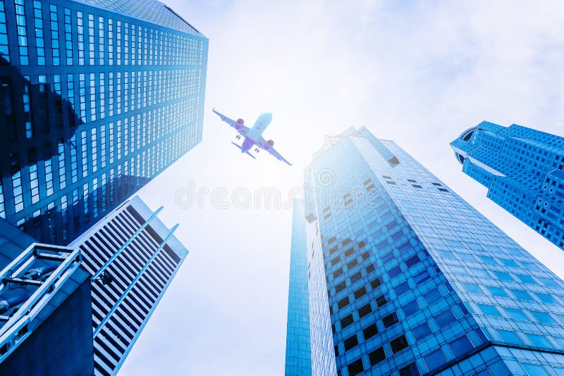 Vliegtuig die over moderne glas en staalbureaugebouwen vliegen in Singapore stock fotografie Vliegtuig die over moderne glas en staalbureaugebouwen vliegen in Singapore stock fotografie