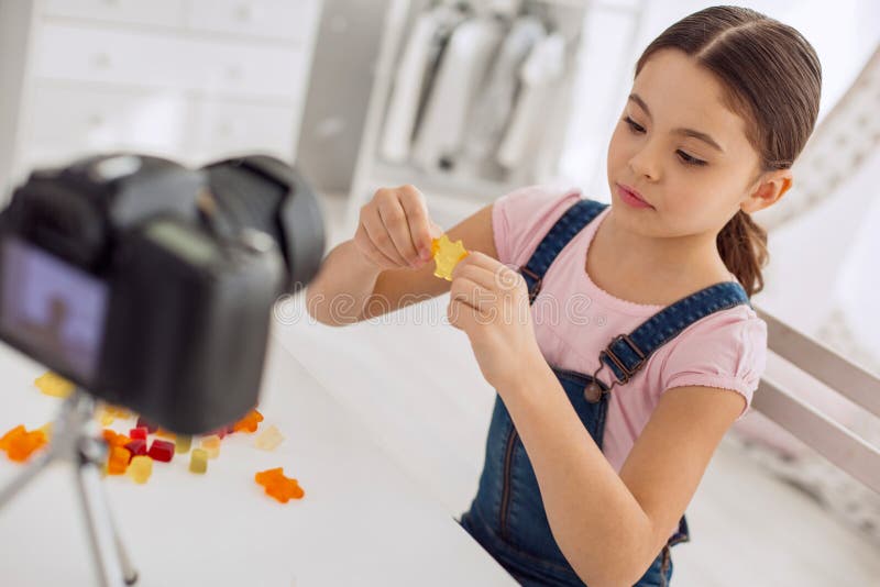 Une vlogueuse charmante comparant différentes marques de bonbons gélifiés photo stock