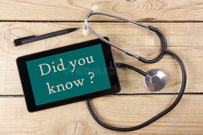 Did you know - Workplace of a doctor. Tablet, medical stethoscope, black pen on wooden desk background. Top view. Did you know - Workplace of a doctor. Tablet, medical stethoscope, black pen on wooden desk background. Top view.