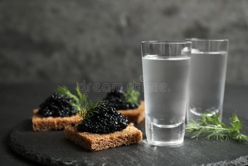 Vodka russa fredda e panini con caviale nero sul tavolo