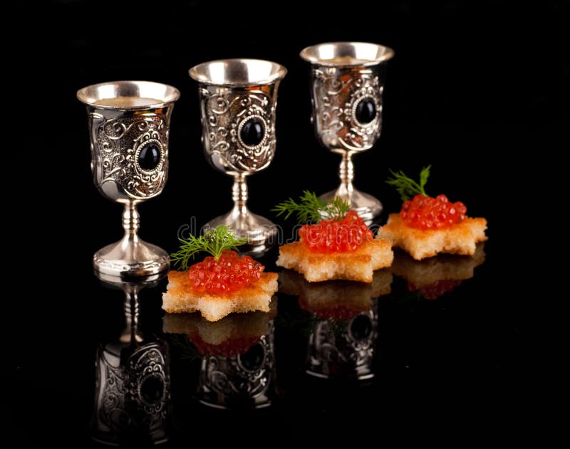 Vodka y caviar rojo en las mercancías de plata imagen de archivo libre de regalías Vodka y caviar rojo en las mercancías de plata imagen de archivo libre de regalías