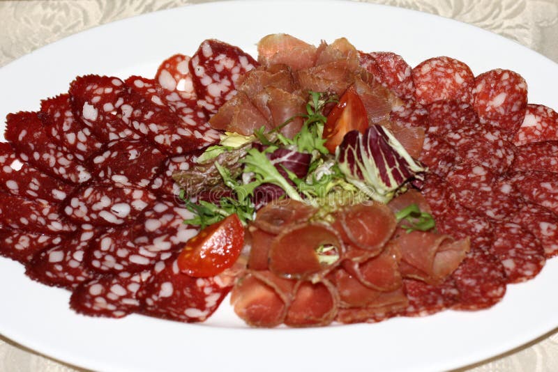 Voedseldienblad met salami, stukken van gesneden ham, worst, tomaten, salade en groente - Vleesschotel met selectie die - snijden stock foto Voedseldienblad met salami, stukken van gesneden ham, worst, tomaten, salade en groente - Vleesschotel met selectie die - snijden stock foto