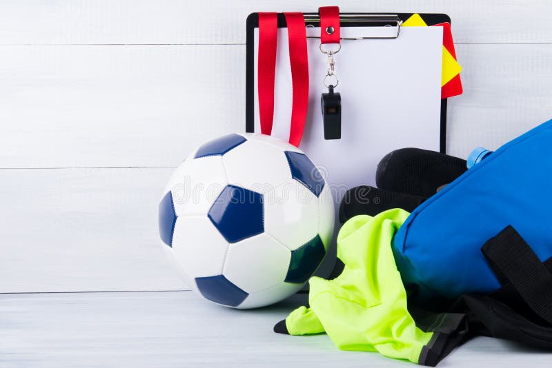 Voetbalbal, fluitje, sanctiekaarten en een tablet voor het registreren van een rechter en een sportkleding in een zak, op een gri royalty-vrije stock afbeeldingen Voetbalbal, fluitje, sanctiekaarten en een tablet voor het registreren van een rechter en een sportkleding in een zak, op een gri royalty-vrije stock afbeeldingen