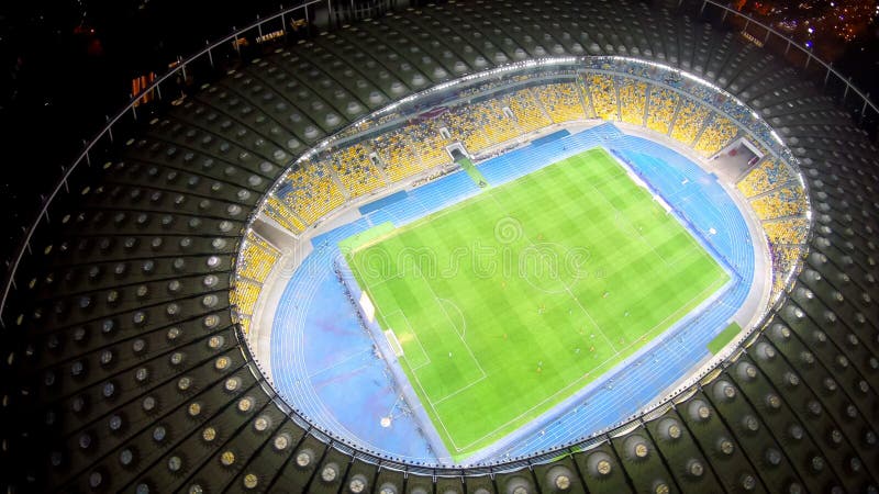 Voetballers die op groot groen stadion, verbazende cityscape opleiden, die gelijke gelijk maken stock afbeelding Voetballers die op groot groen stadion, verbazende cityscape opleiden, die gelijke gelijk maken stock afbeelding
