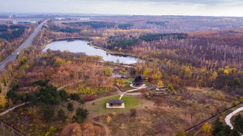 Aerial view of old wooden church in the autumn park over lake. Drone shot. Moldova, kishinev. Aerial view of old wooden church in the autumn park over lake. Drone shot. Moldova, kishinev